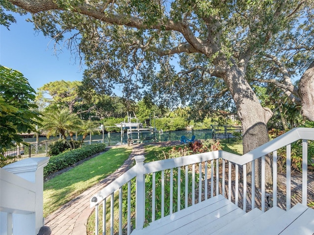 deck featuring a yard, a dock, and a water view