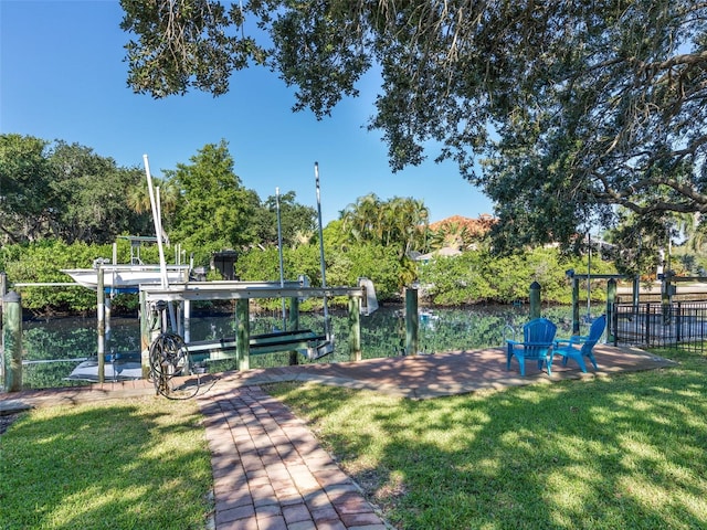 view of home's community featuring a lawn and a boat dock