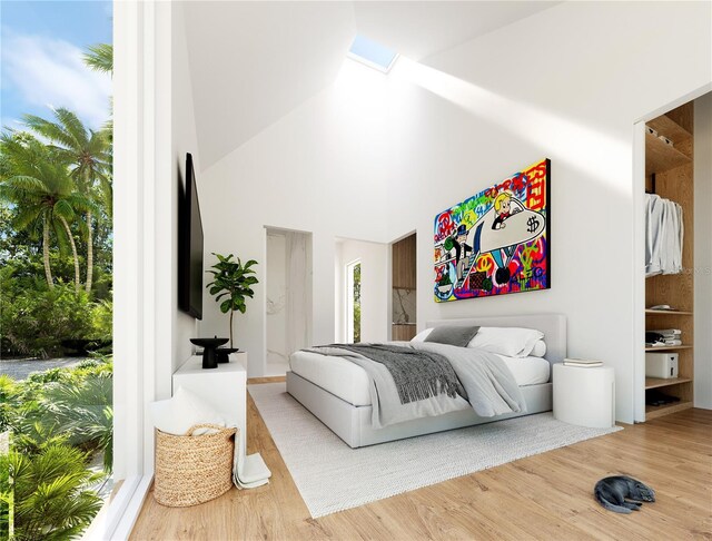 bedroom featuring wood-type flooring, ensuite bathroom, a high ceiling, and a skylight