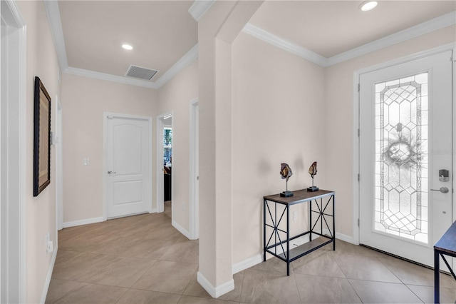 entryway with light tile patterned floors and crown molding