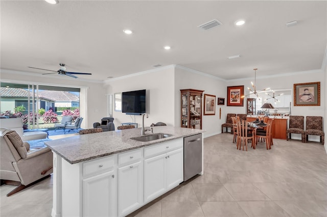 kitchen with a center island with sink, white cabinets, sink, stainless steel dishwasher, and decorative light fixtures