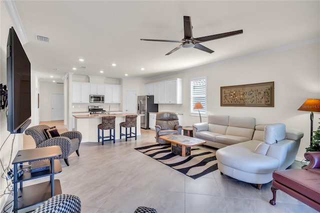 tiled living room featuring ceiling fan, sink, and crown molding