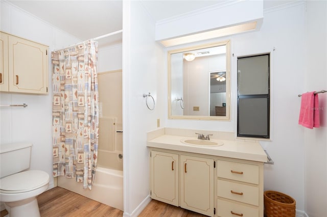 full bathroom with toilet, vanity, hardwood / wood-style floors, crown molding, and shower / tub combo with curtain