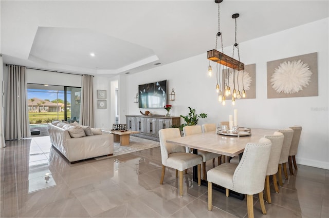 tiled dining space featuring a tray ceiling