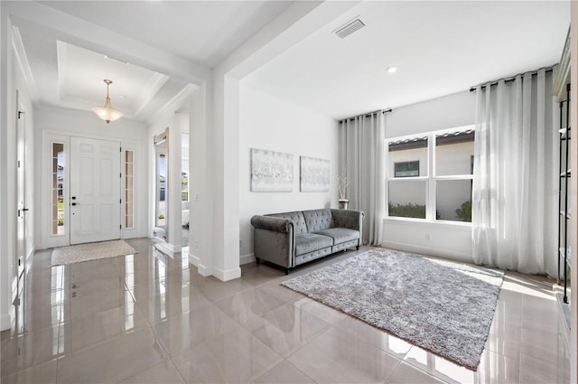 tiled entrance foyer featuring a tray ceiling