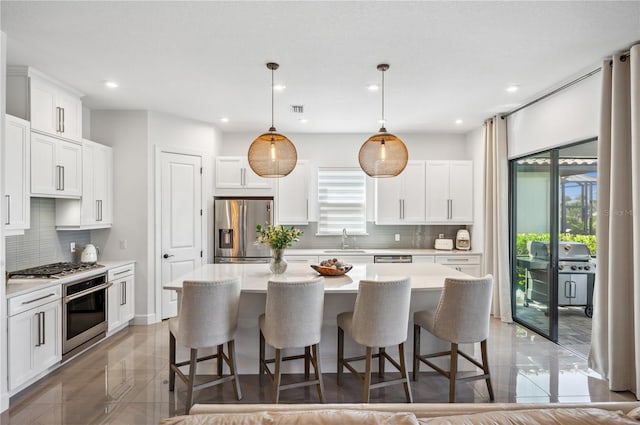 kitchen featuring tasteful backsplash, a kitchen island, appliances with stainless steel finishes, and sink