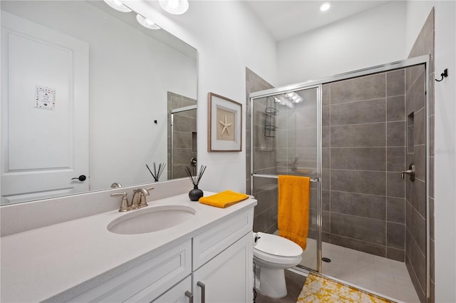 bathroom featuring toilet, large vanity, and walk in shower