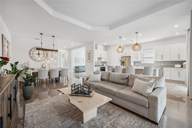 living area featuring recessed lighting and a raised ceiling