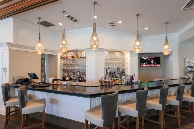 bar with dark hardwood / wood-style flooring, hanging light fixtures, crown molding, and white cabinets