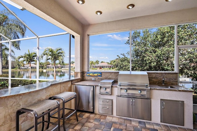 sunroom with a water view, plenty of natural light, and sink