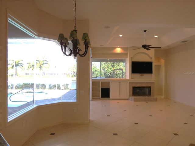 interior space featuring pendant lighting, ceiling fan with notable chandelier, and tile patterned flooring