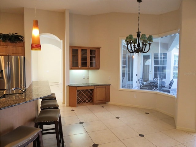 tiled dining room featuring sink and a notable chandelier