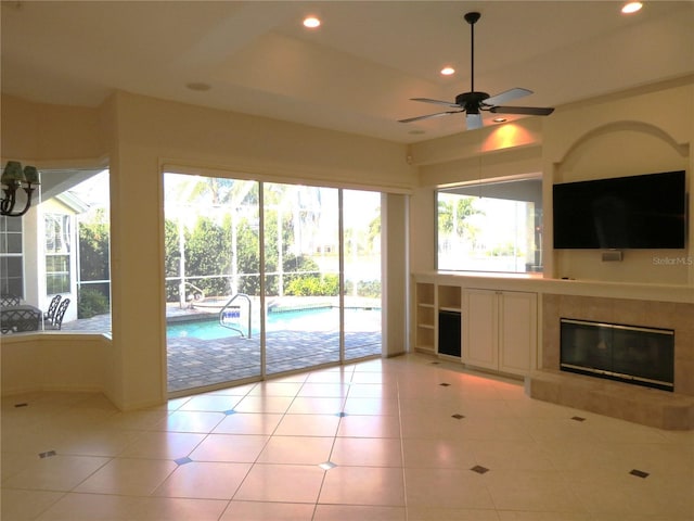 unfurnished living room featuring light tile patterned flooring, ceiling fan, and a fireplace