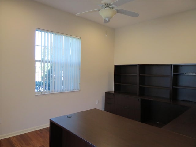 unfurnished office featuring dark wood-type flooring and ceiling fan