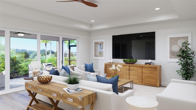 living room with a tray ceiling, ceiling fan, and light hardwood / wood-style flooring