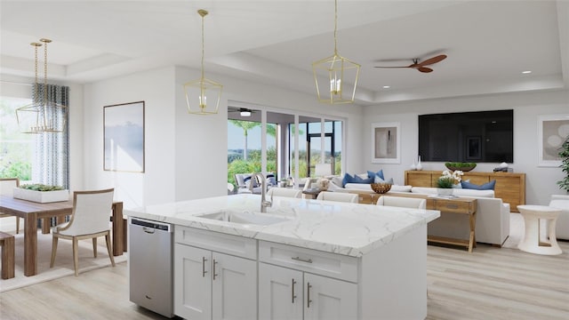 kitchen with white cabinetry, pendant lighting, a tray ceiling, and sink