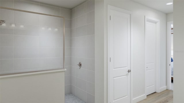 bathroom featuring a tile shower and hardwood / wood-style flooring