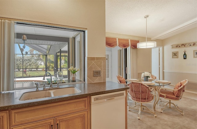 kitchen with a textured ceiling, vaulted ceiling, sink, dishwasher, and hanging light fixtures