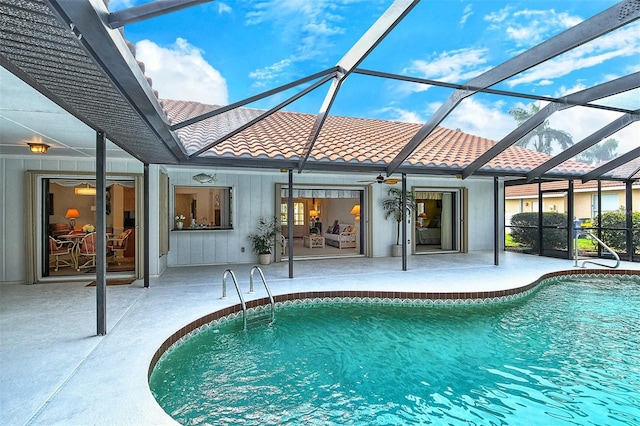 view of swimming pool featuring glass enclosure and a patio area