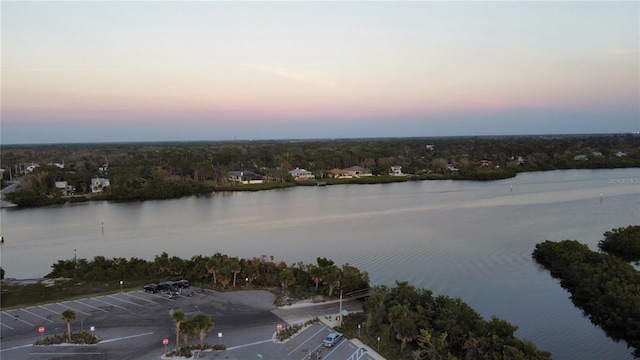 aerial view at dusk featuring a water view