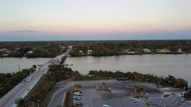 aerial view at dusk featuring a water view