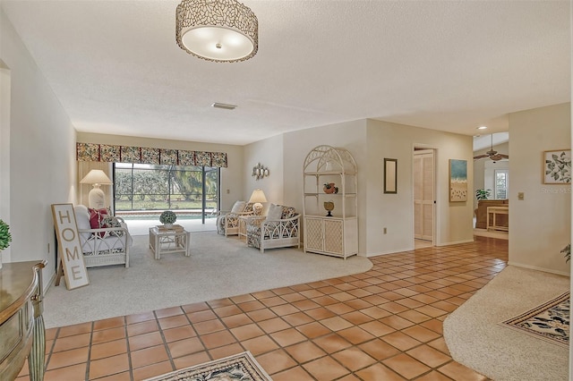 unfurnished living room with tile patterned floors, ceiling fan, and a textured ceiling