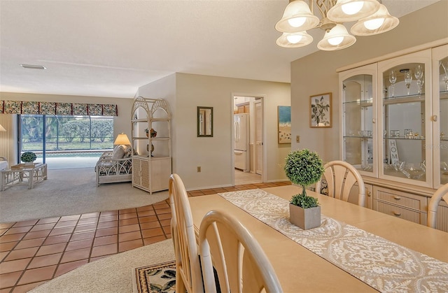 tiled dining area featuring a notable chandelier