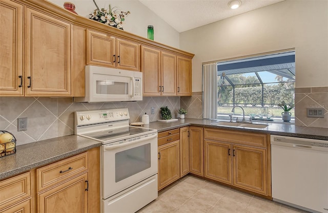 kitchen featuring tasteful backsplash, a textured ceiling, white appliances, sink, and lofted ceiling