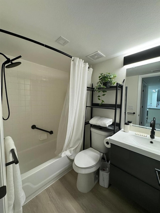 full bathroom with a textured ceiling, vanity, shower / bath combination with curtain, wood-type flooring, and toilet