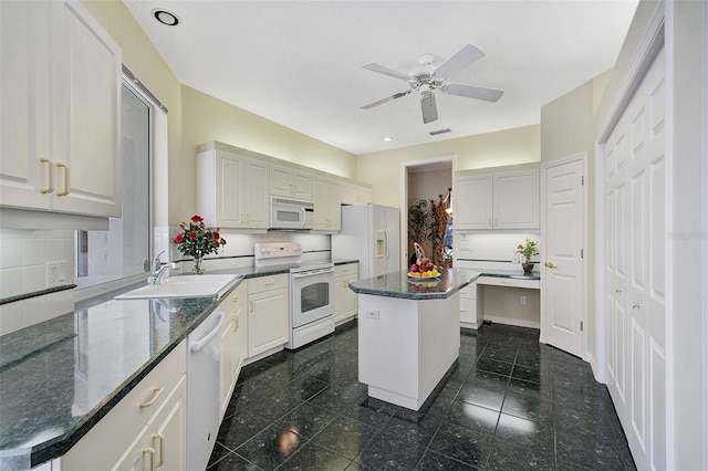 kitchen featuring white cabinets, a center island, ceiling fan, white appliances, and sink