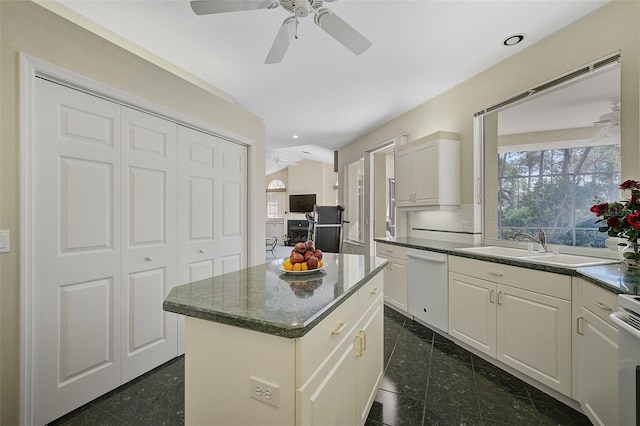 kitchen featuring dark tile flooring, white cabinets, ceiling fan, and a center island