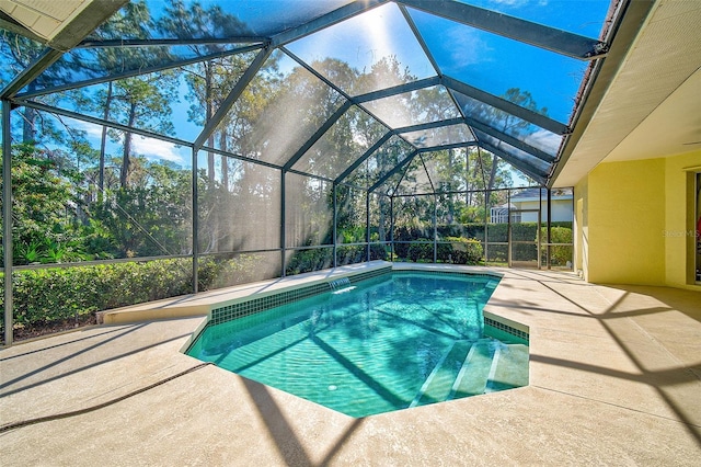 view of swimming pool featuring glass enclosure, pool water feature, and a patio