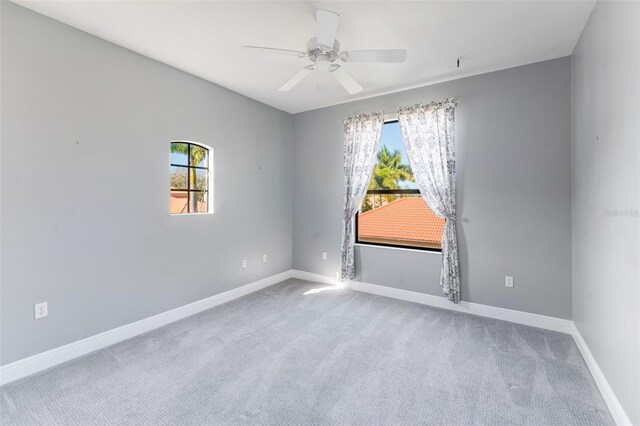 carpeted spare room featuring ceiling fan