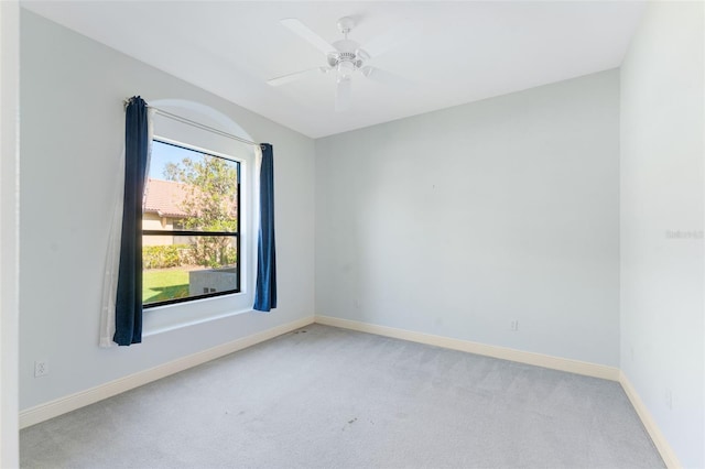 carpeted spare room featuring ceiling fan