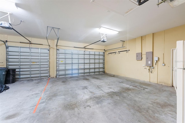 garage with a garage door opener and white refrigerator