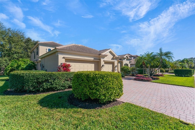 view of front of property featuring a front lawn and a garage