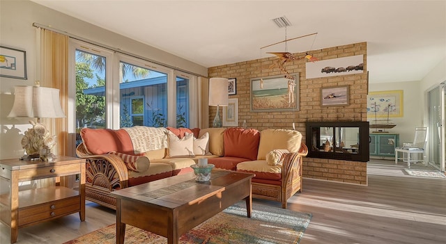 interior space with brick wall, light hardwood / wood-style floors, and a fireplace