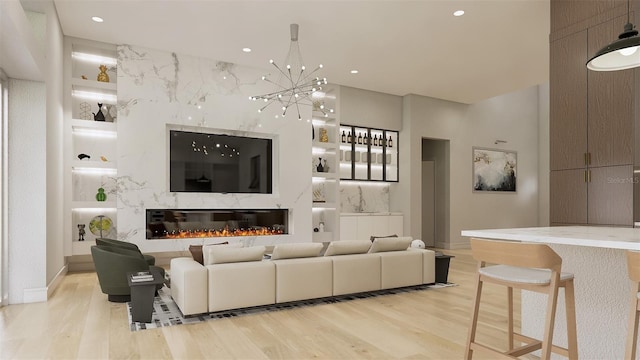 living room with an inviting chandelier, built in features, and light hardwood / wood-style floors