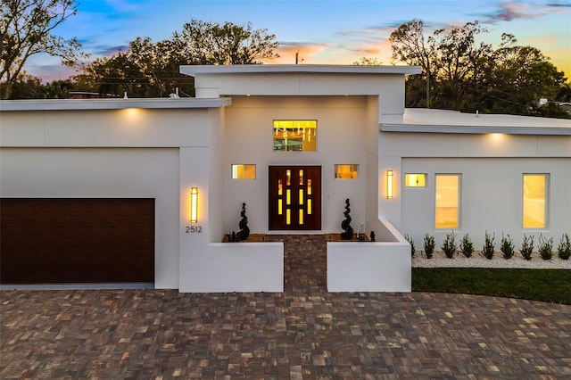 view of front facade with an attached garage and stucco siding