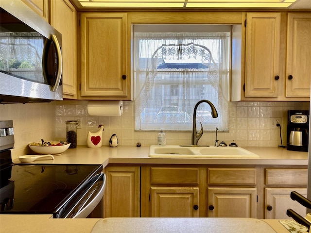 kitchen with electric stove, tasteful backsplash, and sink