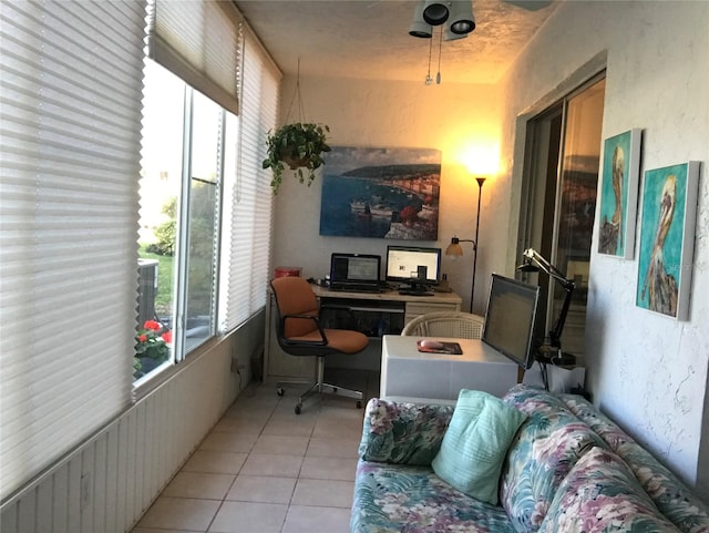 interior space with light tile flooring, a healthy amount of sunlight, and ceiling fan