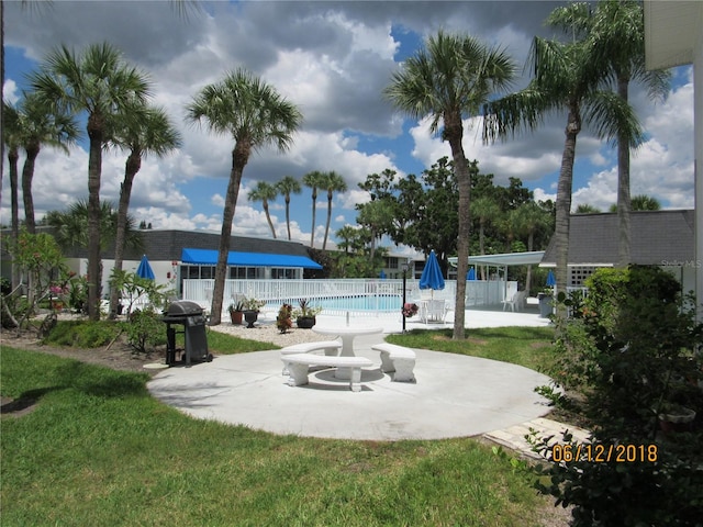 surrounding community featuring a swimming pool, a yard, and a patio