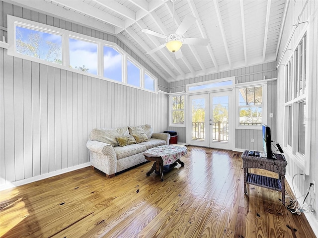 living room featuring a healthy amount of sunlight, vaulted ceiling with beams, light hardwood / wood-style flooring, and french doors