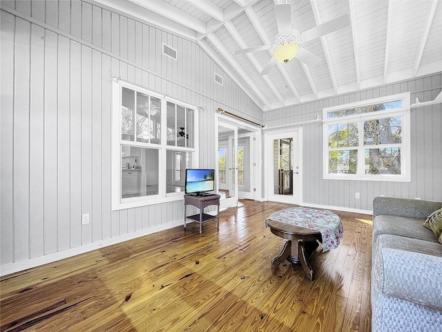 living room with lofted ceiling with beams, wood-type flooring, ceiling fan, and a wealth of natural light