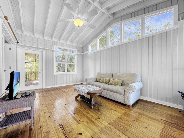 living room with plenty of natural light, ceiling fan, vaulted ceiling with beams, and light hardwood / wood-style flooring