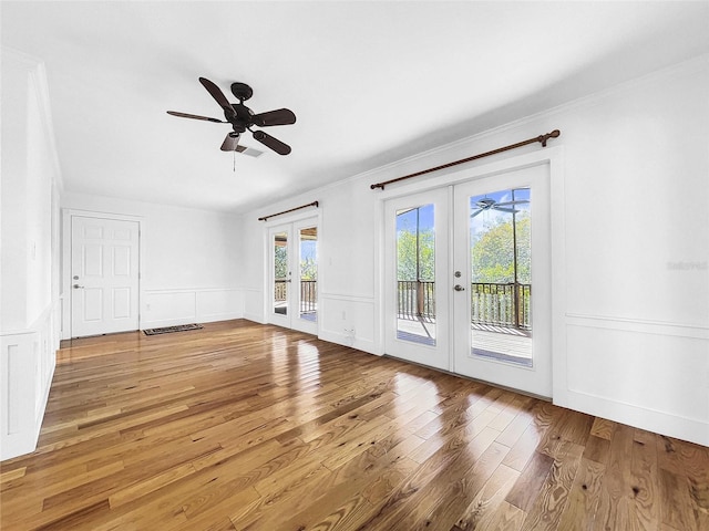 unfurnished room featuring french doors, light hardwood / wood-style floors, ornamental molding, and ceiling fan