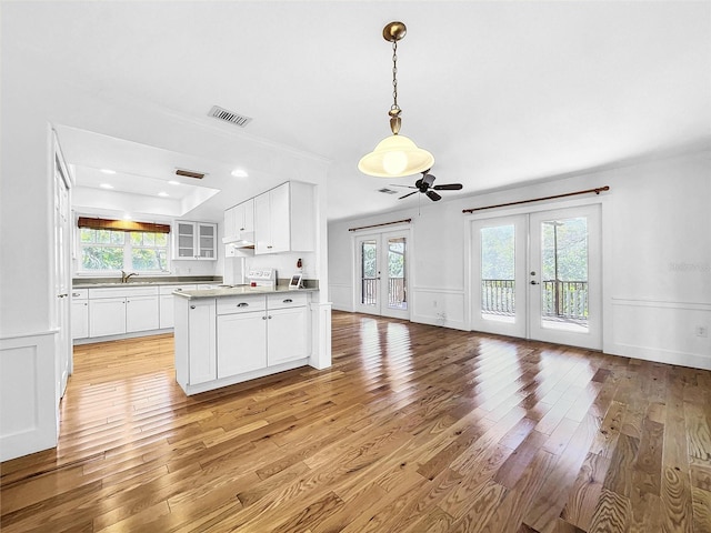 kitchen featuring light hardwood / wood-style floors, ceiling fan, white cabinetry, and a wealth of natural light