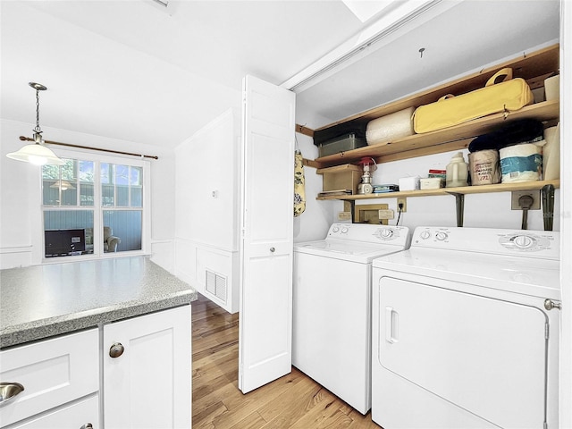 clothes washing area with washer hookup, washer and clothes dryer, electric dryer hookup, and light hardwood / wood-style flooring