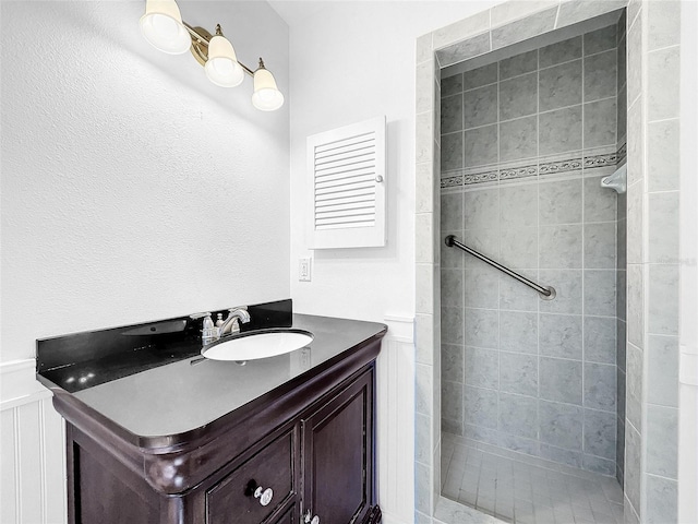 bathroom with vanity and tiled shower