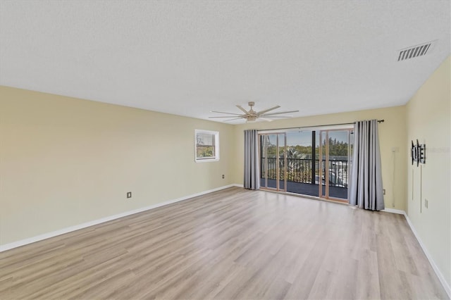 empty room featuring a textured ceiling, light hardwood / wood-style floors, and ceiling fan